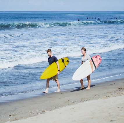 Dos surfistas caminando en la playa, noticia hoteles Palace