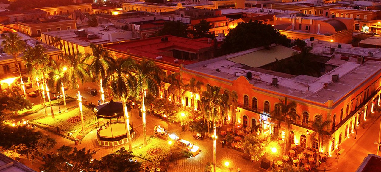 [Imagen nocturna de la Plazuela Machado con sus luces y restaurantes]